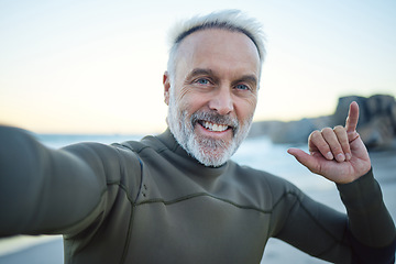 Image showing Beach, selfie and a happy elderly surfer man at water on weekend morning. Freedom, ocean and happiness, fun on retirement surf holiday in Hawaii. Health, nature and senior on video call at the sea.