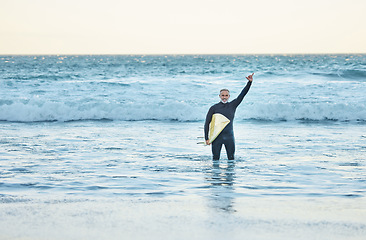 Image showing Shaka, surf and sports with a mature man doing a hand gesture in the beach water during summer. Surfer, sea and nature with a male athlete in the ocean for workout, fitness or exercise in a wetsuit