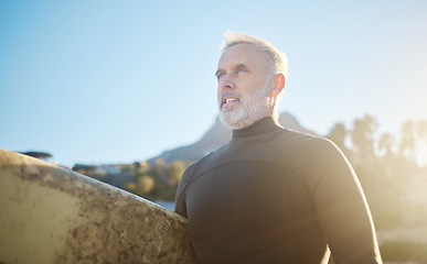 Image showing Surfboard, fitness and senior man surfer, ready to surf in Costa Rica on summer vacation or holiday. Travel, retired and elderly male preparing for surfing sports, recreation or training exercise.