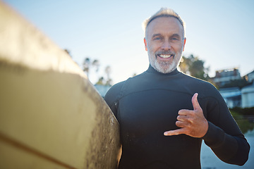 Image showing Beach, surf board and a happy elderly surfer man with hand sign and smile. Freedom, water sports and happiness, fun on retirement holiday in Australia. Health, fitness and senior ready for surfing.