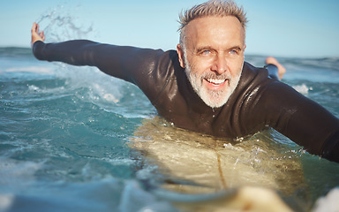 Image showing Beach, water and old man surfer swimming on a summer holiday vacation in retirement with freedom in Bali. Smile, ocean and senior surfing or body boarding enjoying a healthy exercise on sea of Island