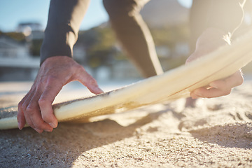 Image showing Surfer, beach and zoom of hands, sand and surfboard in sunshine for fitness, health and adventure in summer. Man and sea to surf waves in ocean to relax, workout and exercise in Australia