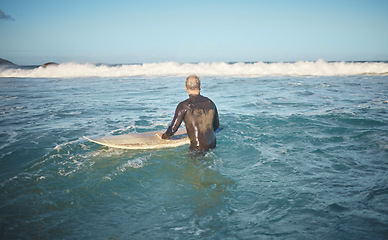 Image showing Surfer and man in water watching wave for high tide while holding surfboard at sunny USA beach. Retirement person enjoying surfing sport leisure in California waiting for ocean level to rise.