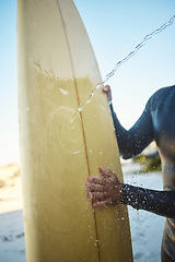 Image showing Beach, surfing and man cleaning a board while on holiday at the ocean in Australia during summer. Hands of a surfer washing his surfboard at the sea during travel vacation for adventure on an island