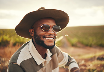 Image showing Farm, agriculture and sustainability with a black man farmer outdoor on a grass field or land for organic farming. Agricultural, sustainable and green with a male wearing a hat and sunglasses outside