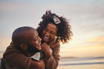 Image showing Love, travel and fun couple at beach enjoying summer vacation or honeymoon at sunset with a piggy back ride while being playful. Laughing, energy and seaside holiday with black man and woman together