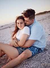 Image showing Couple, relax and hug for love on a beach sitting and enjoying time together in the outdoors. Young man hugging woman relaxing on a sandy ocean coast in Costa Rica for romantic relationship in nature