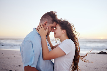 Image showing Couple, love and beach at sunset with face in hands for travel, vacation or holiday by the sea. Man, woman and ocean show happiness, smile and care together by waves, sand and summer sunshine in Bali