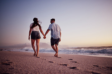 Image showing Love, holding hands and couple walking on the beach relax, bond and enjoy romantic quality time together in Israel. Peace, freedom and ocean air for man and woman on sea sand travel for wellness calm