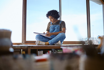 Image showing Focused woman, student and drawing by window in creative studio or workshop with a book indoors. Young female designer or artist sketching, learning and sitting in a art shop or school in Brazil