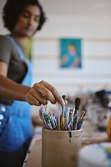 Image showing Hand, creative woman and art brush of artistic student picking paintbrush for work at the studio or workshop. Female artist hands taking a brushes from a bucket for design, painting or project