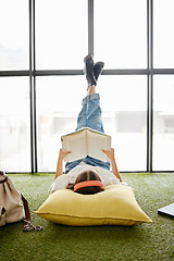 Image showing Reading, education and book with a woman student relax on the floor in a break or study room on university campus. College, scholarship and learning with a female studying for growth and development