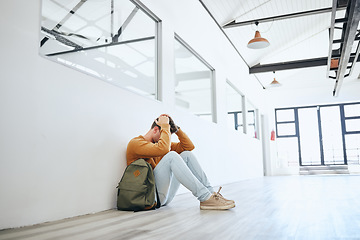 Image showing Young man, mental health and stress student, depressed and on floor holding head in empty room. Burnout, male and frustrated with fear, social anxiety and anxious with tired, overworked and scared.