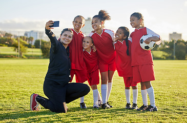 Image showing Soccer field, girl team and coach selfie for social media after training, competition and game together outdoors. Happy children, smile teacher and students community football academy taking photos