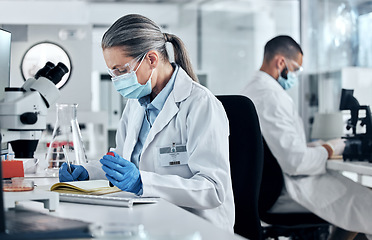 Image showing Science, dna blood and covid research with a woman writing in a notebook for innovation and breakthrough in a lab. Analytics, technology and medicine with a female scientist at work in a laboratory