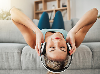 Image showing Relax, music and freedom with a woman listening to audio on headphones while lying on a sofa in the living room of her home. Wellness, mental health and streaming with a young female alone in a house