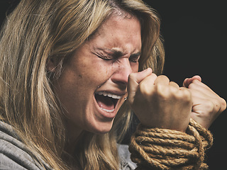 Image showing Danger, scared and horror woman scream for help with hands tie and trapped by rope on black studio background. Violence, sad or anxiety female with crime, fear and prisoner, crying for mental health