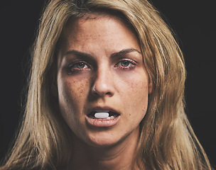 Image showing Woman, face and pill for drug in addiction for substance abuse to cure pain and suffering over black studio background. Portrait of female addict or model addicted to medical pills, help and rehab