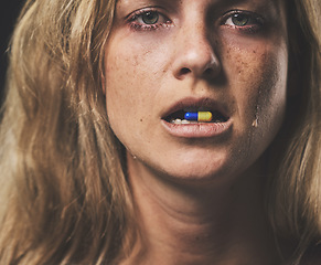 Image showing Depression, portrait and girl with pill in her mouth with emotional tears on face from crying. Sad, unhappy and isolated woman with mental health problem taking psychiatry medicine closeup.