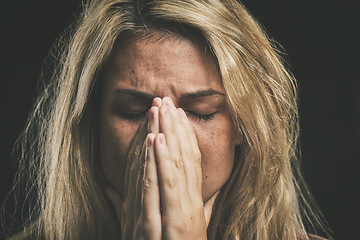 Image showing Stress, anxiety and depression with a mental health woman suffering from a headache or migraine in a studio on a dark background. Cancer and sad young female covering her face in fear and distress