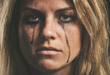 Image showing Face, crying and domestic violence with a woman victim of abuse in studio with makeup closeup. Sad, fear and pain with a scared female feeling angry or emotional with grief, tears and problems