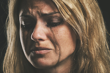 Image showing Sad, depression and woman crying on dark studio background for mental health or psychology awareness. Young, depressed mental illness person tears and smudge makeup for anxiety, violence or fear
