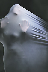 Image showing Psychology, fabric and horror with the hands of a woman trapped in textile in studio on a dark background. Curtain, help and dream with a female ghost draped in white material while looking scary