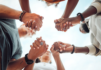 Image showing Holding hands, support and friends praying for spiritual growth, community and gratitude together with sky from below. Group of people in partnership for hope, love and human faith in connection