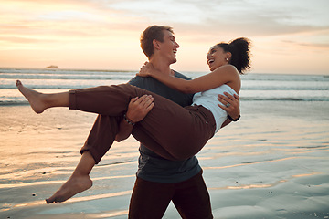 Image showing Man at beach lift woman with love, smile with sunset on travel holiday in Hawaii. Young couple travel to ocean on vacation, happy and play together with sunset at sea or waves in nature during summer