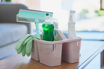 Image showing Basket, cleaning and product on table in home, office or room. Chemical, liquid and bleach in bottle to spray, brush and hygiene against virus, bacteria and germs on desk at workplace in Cape Town