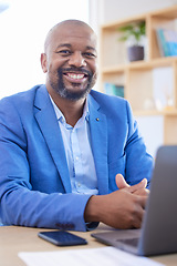 Image showing Happy, smile and portrait of an African businessman sitting at his desk and working on a laptop in his office. Happiness, leader and black man leader planning management documents on computer.