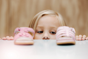 Image showing Kids, fashion and shoes with a girl choosing between footwear while shopping in a retail store. Children, cute and choice with a young female child deciding what shoe to buy for her home wardrobe