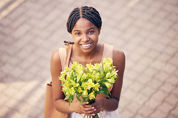 Image showing Flowers, gift and black woman with smile for bouquet for birthday or celebration in the street from above. Face of an African girl with a present of yellow lilies in the road and the city of France