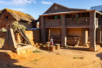 Image showing young Malagasy woman prepares flour with primitive tools in a mortar. Andringitra Mountains, Madagascar