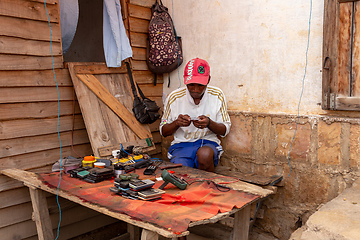 Image showing Malagasy man repairs phones on the street. Miandrivazo, Madagascar