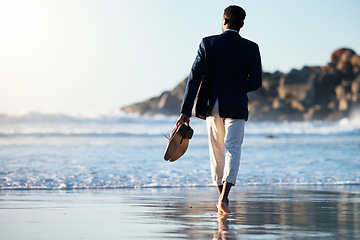 Image showing Business man relax at beach, walking on sand with shoes in hand and calm holiday at California sea. Sunset waves break on weekend, summer travel freedom with zen blue sky and ocean vacation travel