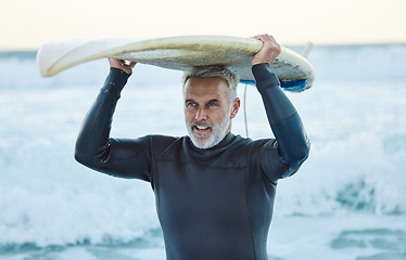 Image showing Senior man, ocean surfer and carrying surfboard on holiday, vacation or summer trip in Canada. Workout, fitness and retired male with board after surfing, water sports and training exercise by sea.