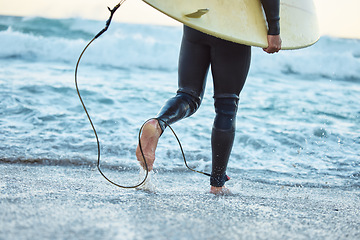 Image showing Legs, surfboard man at beach and ocean waves for fitness, adventure and healthy lifestyle on Bali summer tropical vacation. Surfer running in sea water, relief of stress and surfing in wet suit.