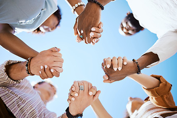 Image showing Diversity, support and people holding hands in trust and unity for community against sky background. Hand of diverse group in solidarity for united team building collaboration and teamwork success