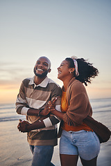 Image showing Happy couple, love and travel at the beach holding hands on date, quality time and romance at sunset. Black woman and man, laughing and walking together by the ocean on honeymoon during summer.