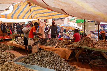 Image showing Malagasy man buys dried fish at a street market. Fishing is one of the livelihoods in Madagascar.
