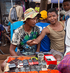 Image showing Malagasy man sell old fashioned cellular mobile phones on the street. Mandoto, Madagascar