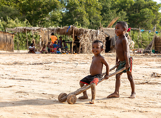 Image showing Boys have fun with a simple toy on wheels at the ferry port in Bekopaka. Madagascar