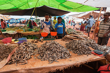 Image showing Malagasy man buys dried fish at a street market. Fishing is one of the livelihoods in Madagascar.