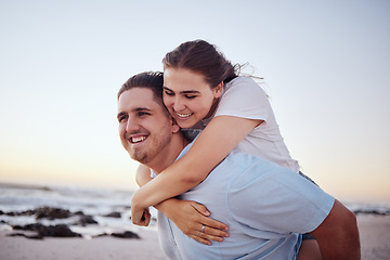 Image showing Beach, love and couple with man carrying girl on his back, happy and smiling. Holiday, dating and romantic vacation by the sea. Young, real happy couple enjoying sunset, ocean and summer fun together