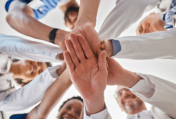 Image showing Hands, doctor and teamwork below in hospital for motivation, inspiration and diversity at work. Medical, team and hand together in collaboration at clinic, help community in healthcare and wellness