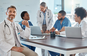 Image showing Portrait of doctor with team in a meeting in the office, having a strategy discussion. Business meeting, teamwork and leadership in healthcare, working online using computers in the medical industry