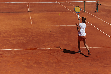 Image showing A young girl showing professional tennis skills in a competitive match on a sunny day, surrounded by the modern aesthetics of a tennis court.