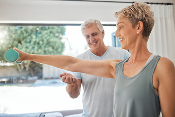 Image showing Fitness, health and senior couple doing exercise in the living room of their comfortable home. Happy, smile and healthy elderly woman doing arm workout with motivation from her husband in retirement.