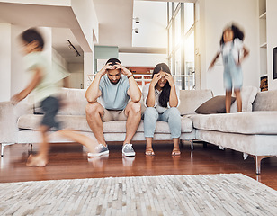 Image showing Stress, headache and family with children running in living room with parents on sofa with fatigue, mental health or tired. Crazy, noise and youth with kids playing with frustrated mother and father